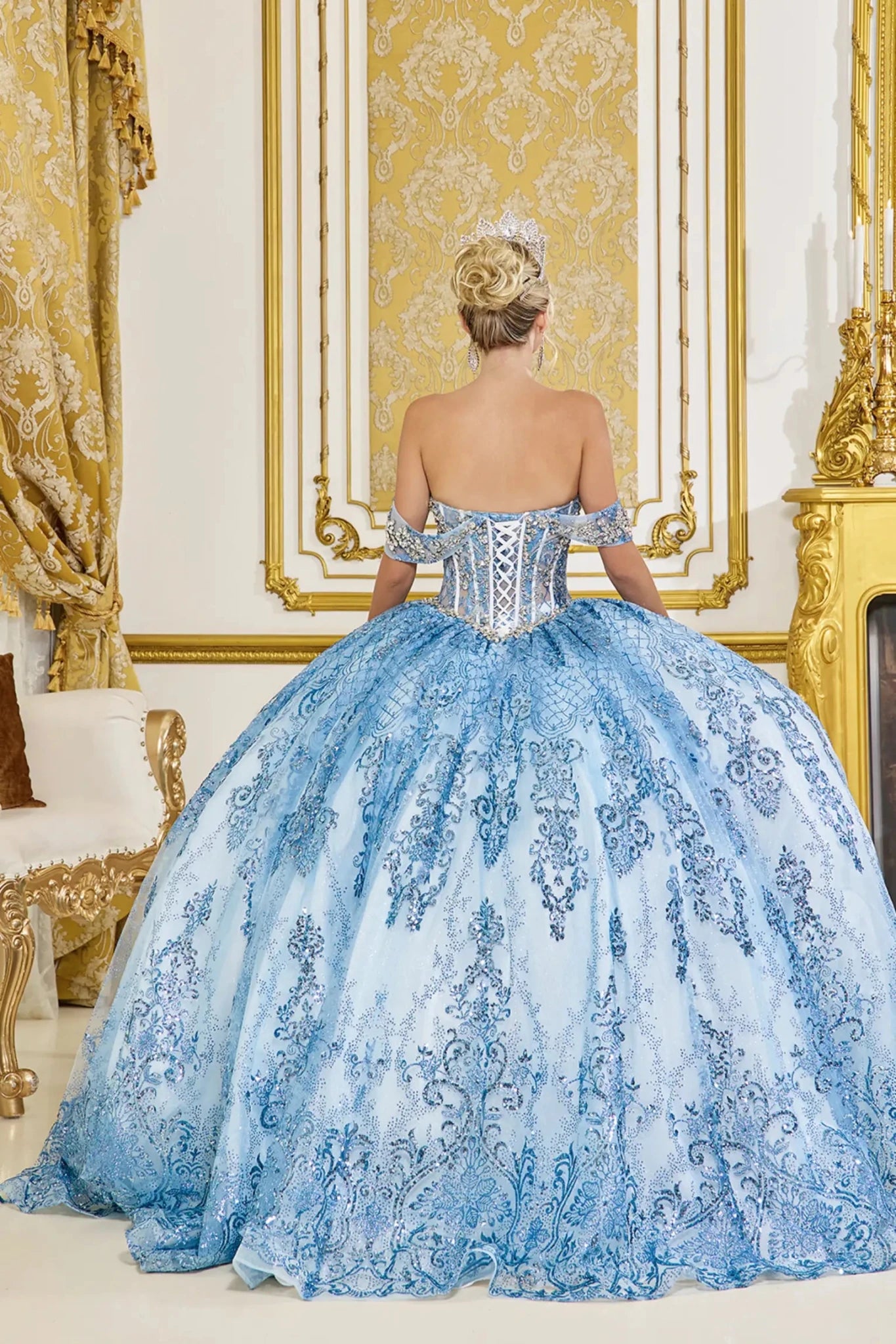 Back view of dusty blue quinceañera ball gown featuring lace-up corset back, off-the-shoulder straps, and voluminous embroidered tulle skirt.