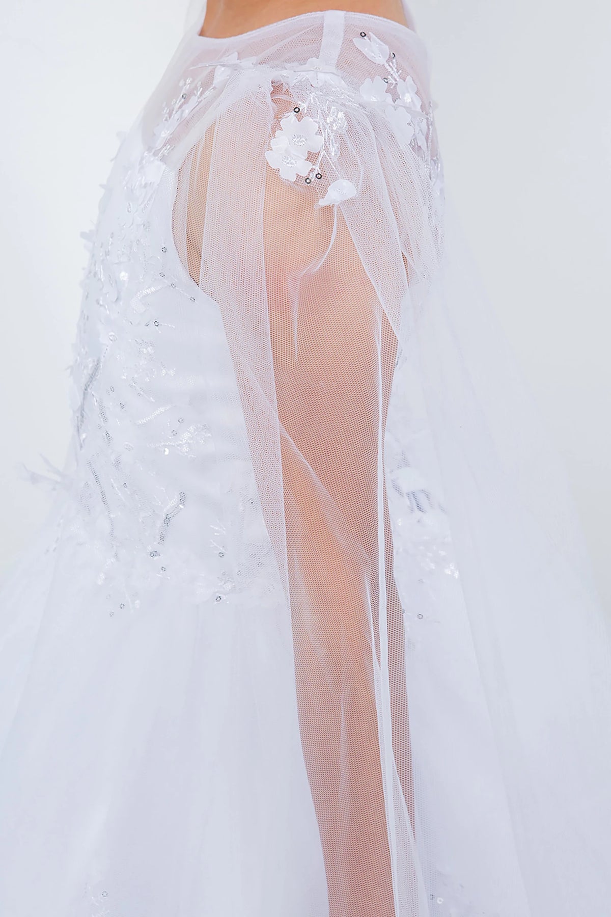 Sheer white lace garment with floral embellishments. Flower girl dress.
