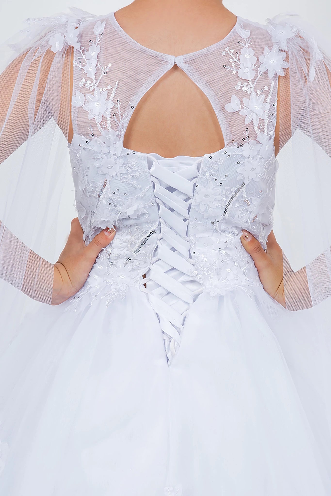 White lace flower girl dress with sheer sleeves and floral details.