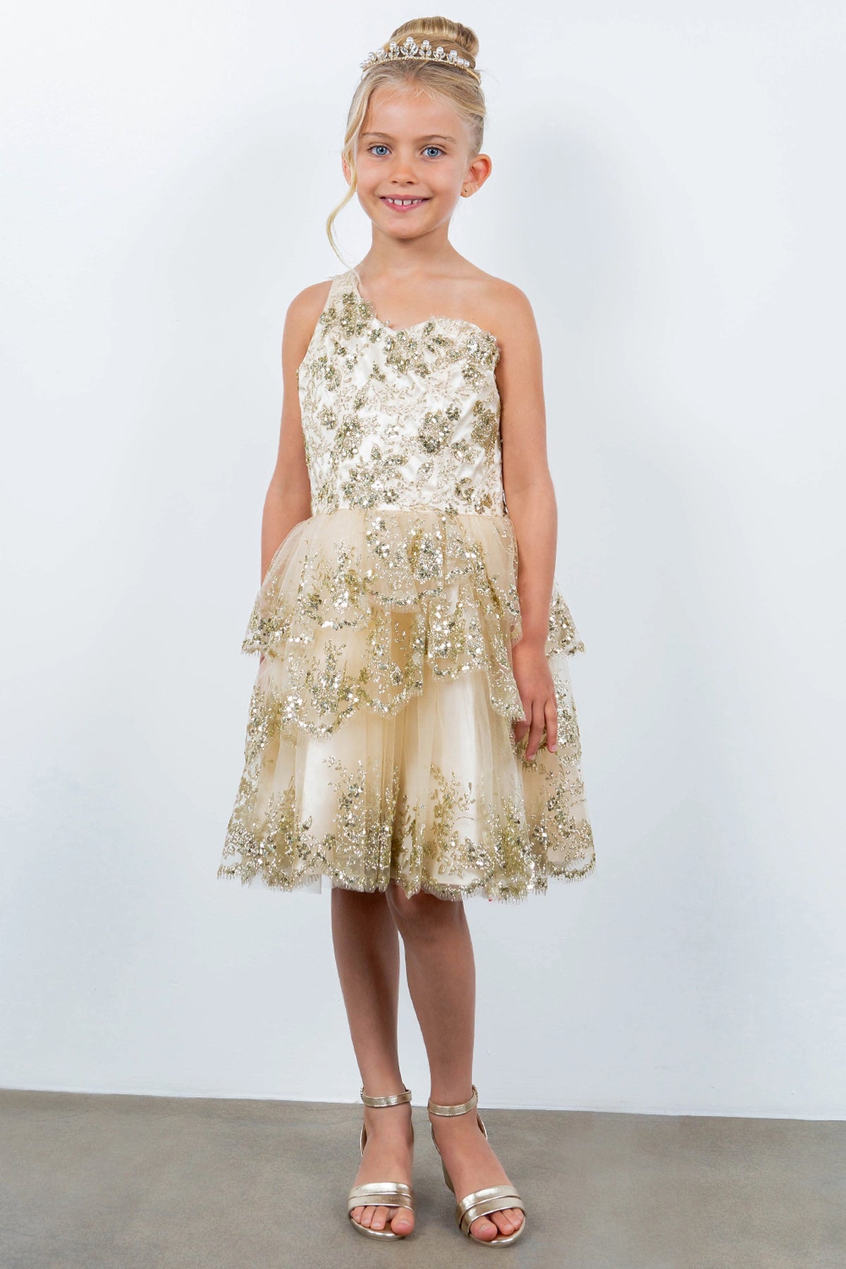Showcasing with a tiered ruffled skirt, this Champagne kids party dress displays elegant detail.