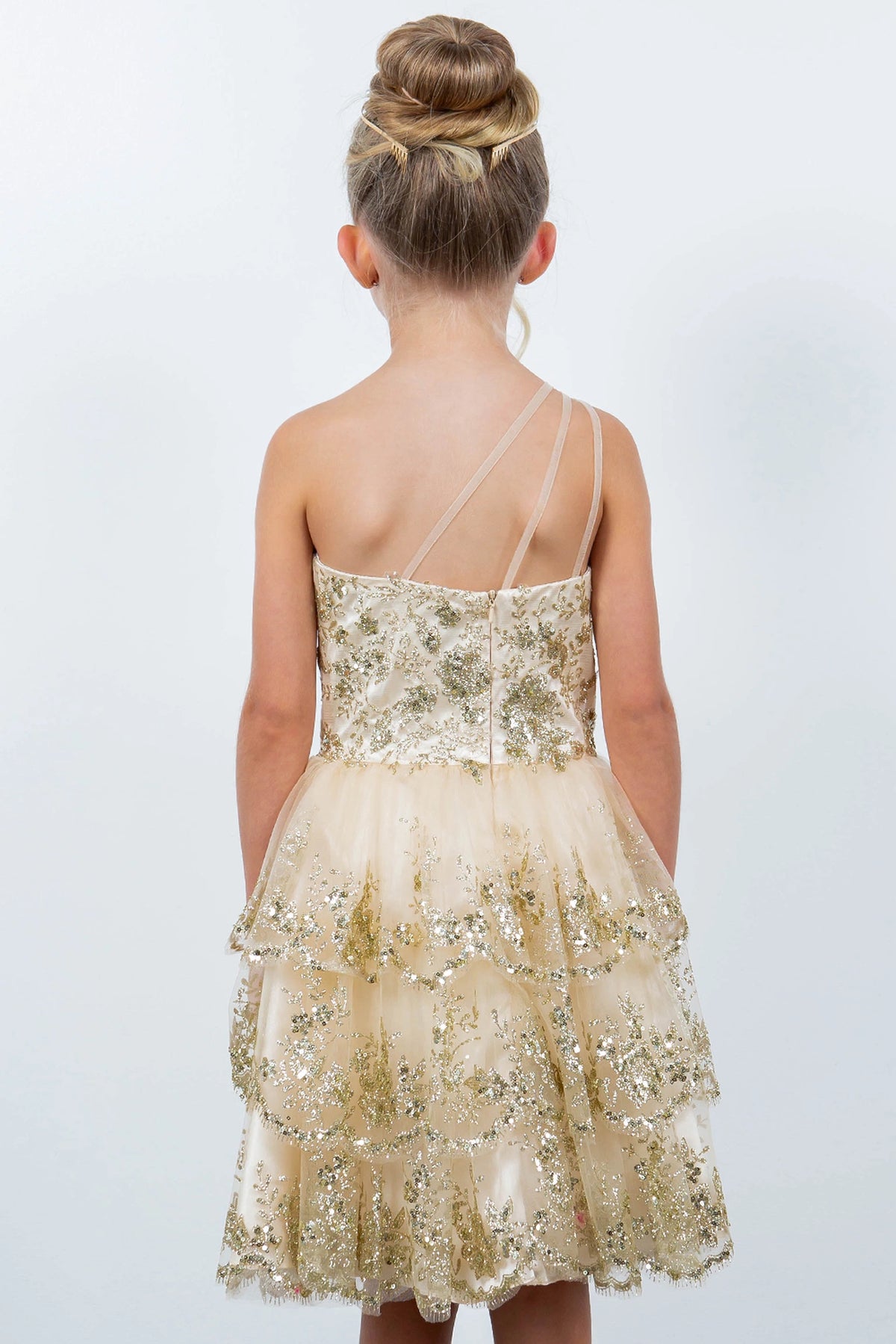 Finished details of a low back with angled straps distinguish the Champagne kids party dress.