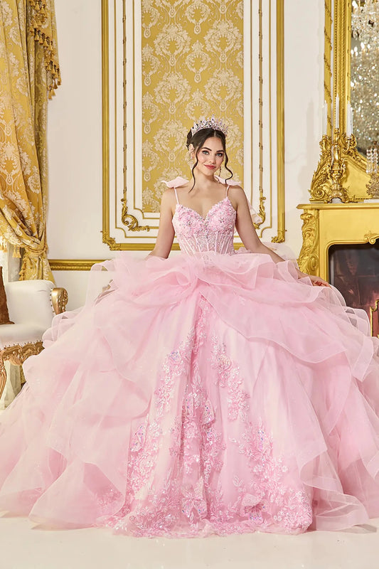 Front view of pink quinceañera ball gown with sweetheart corset bodice, delicate shoulder bows, layered ruffle tulle overskirt, and floral applique detailing