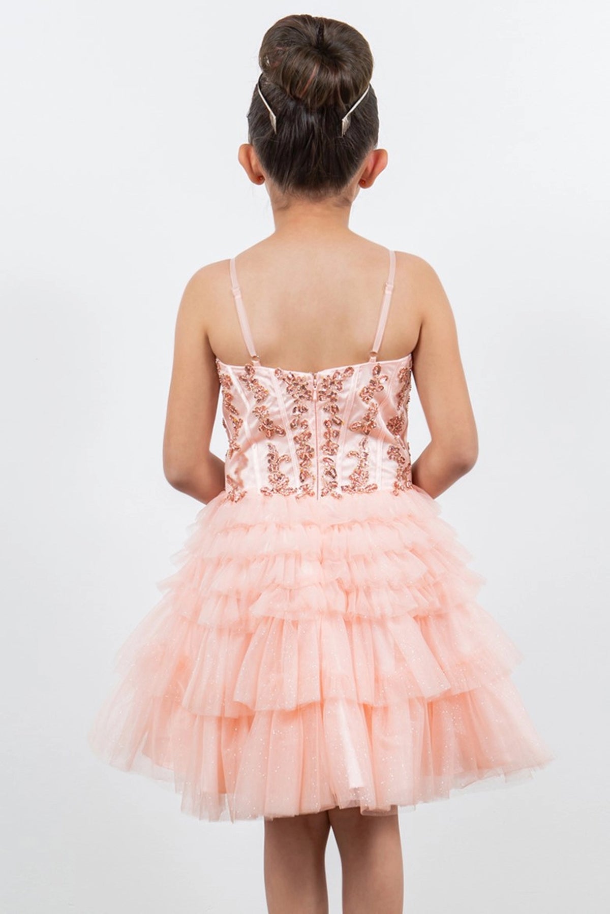 Detailed by a straight back and tiered ruffles, the Blush kids party dress reveals its construction.