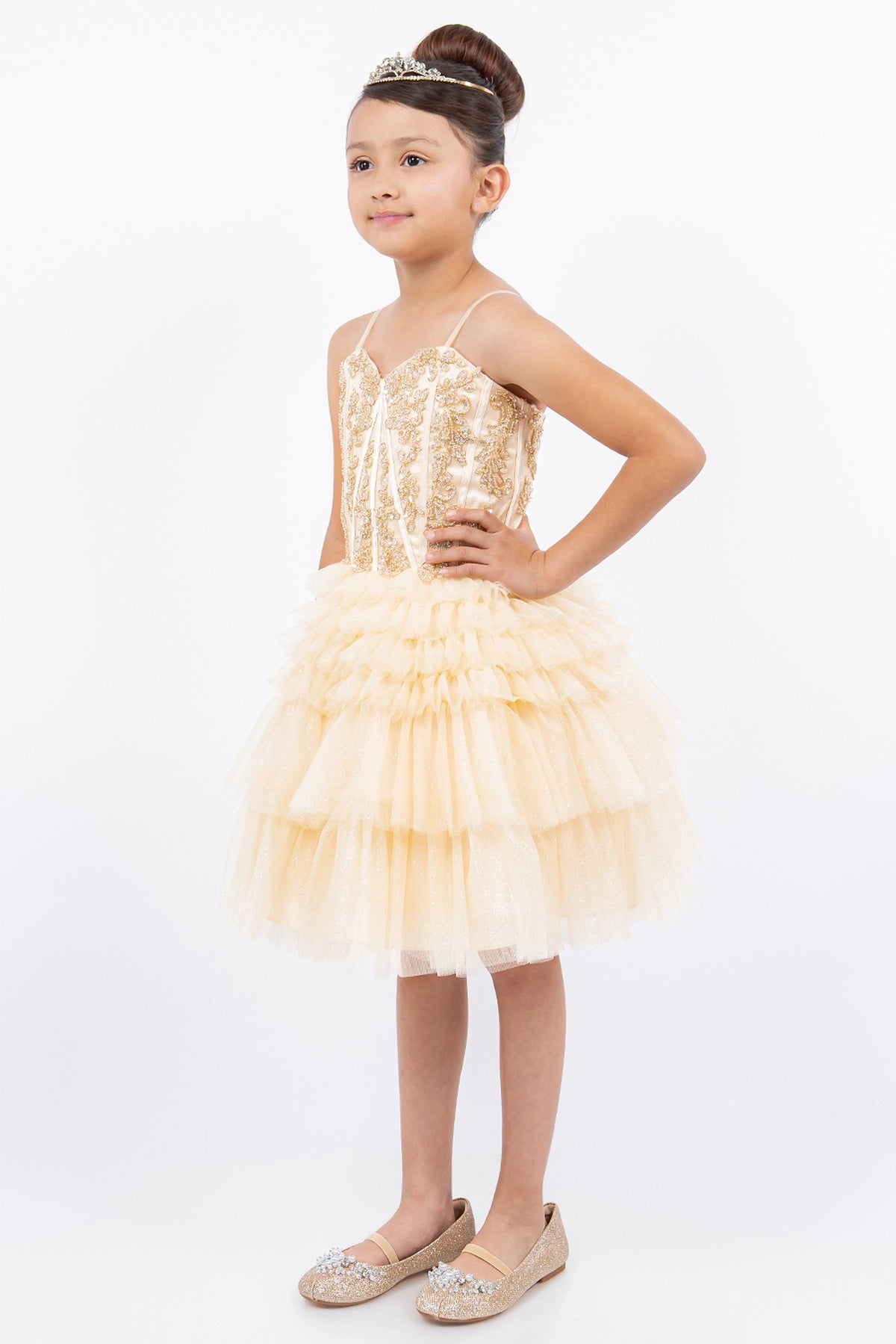 Trimmed by tiered tulle ruffles, the Champagne kids party dress reveals its construction.