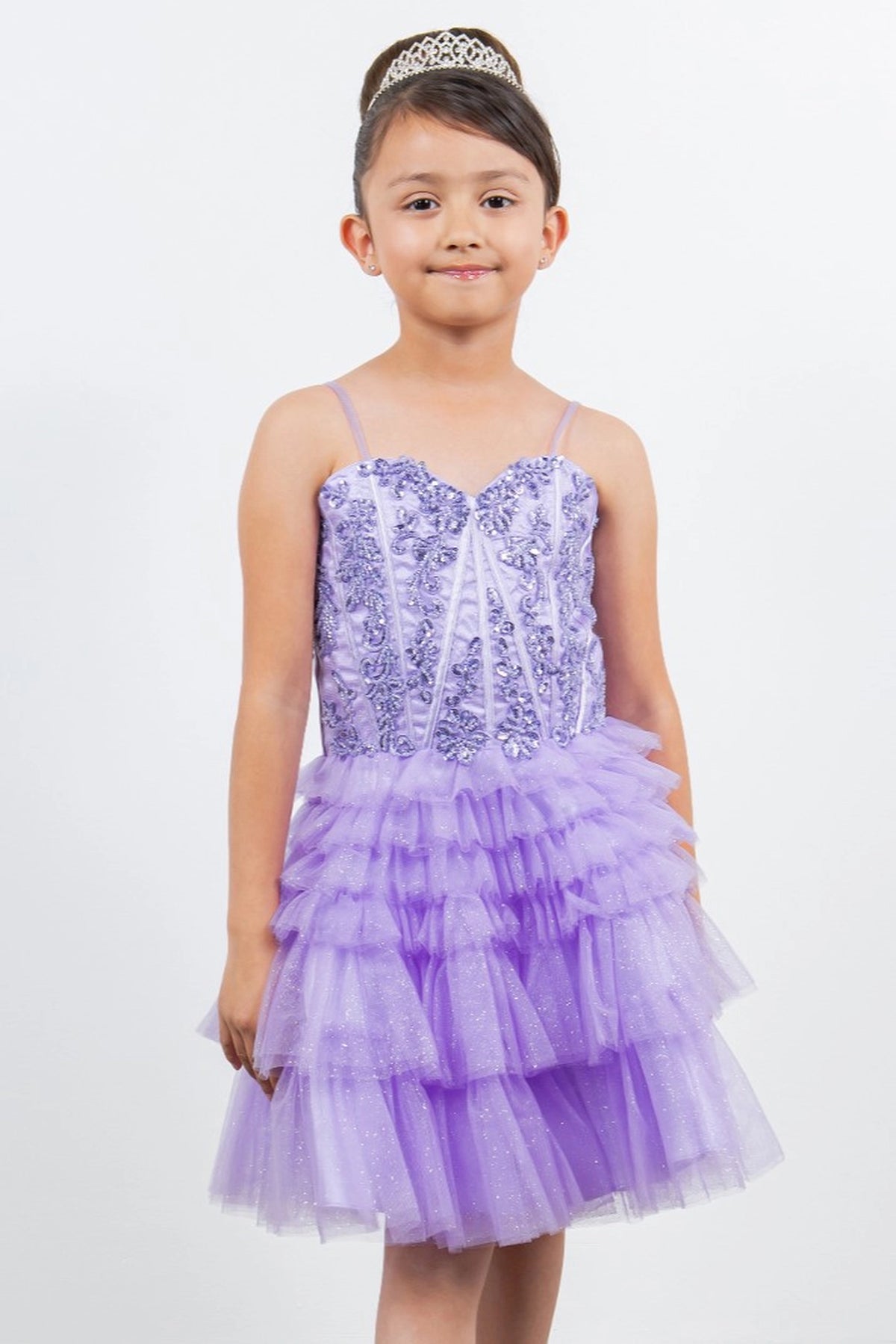 Trimmed by floral bodice embellishments, the Lilac kids party dress reveals its construction.