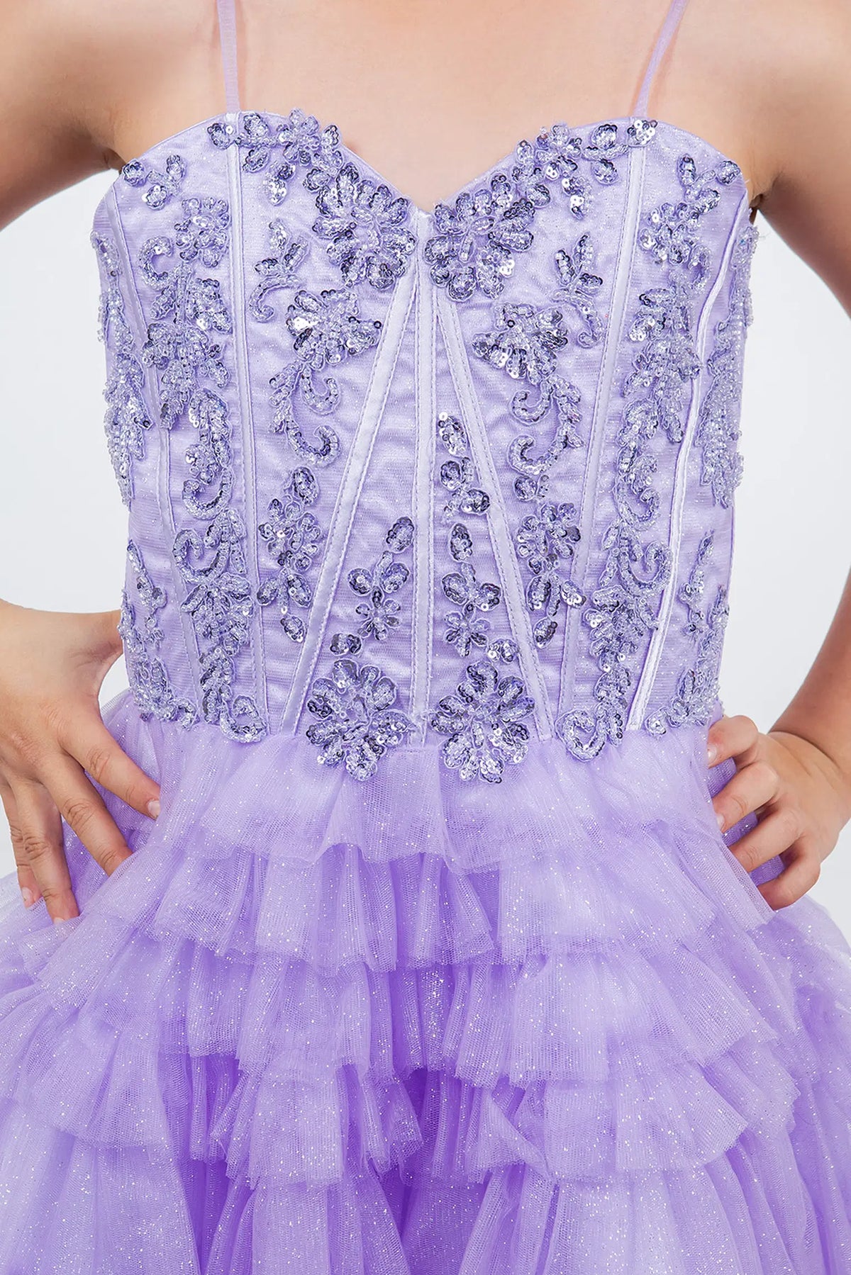 Detailed by tiered tulle ruffles, the Lilac kids party dress reveals its construction.