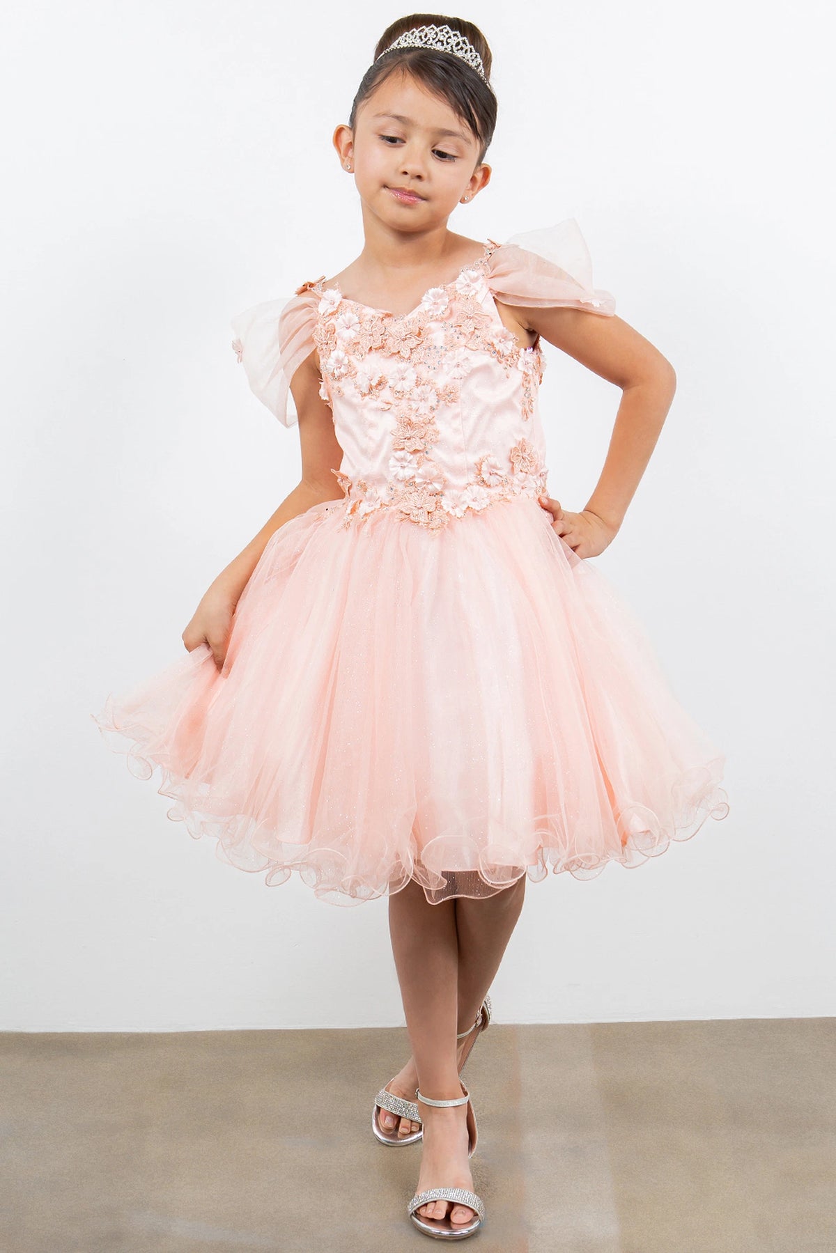 Trimmed by sheer off-shoulder straps, the Blush kids party dress reveals its construction.