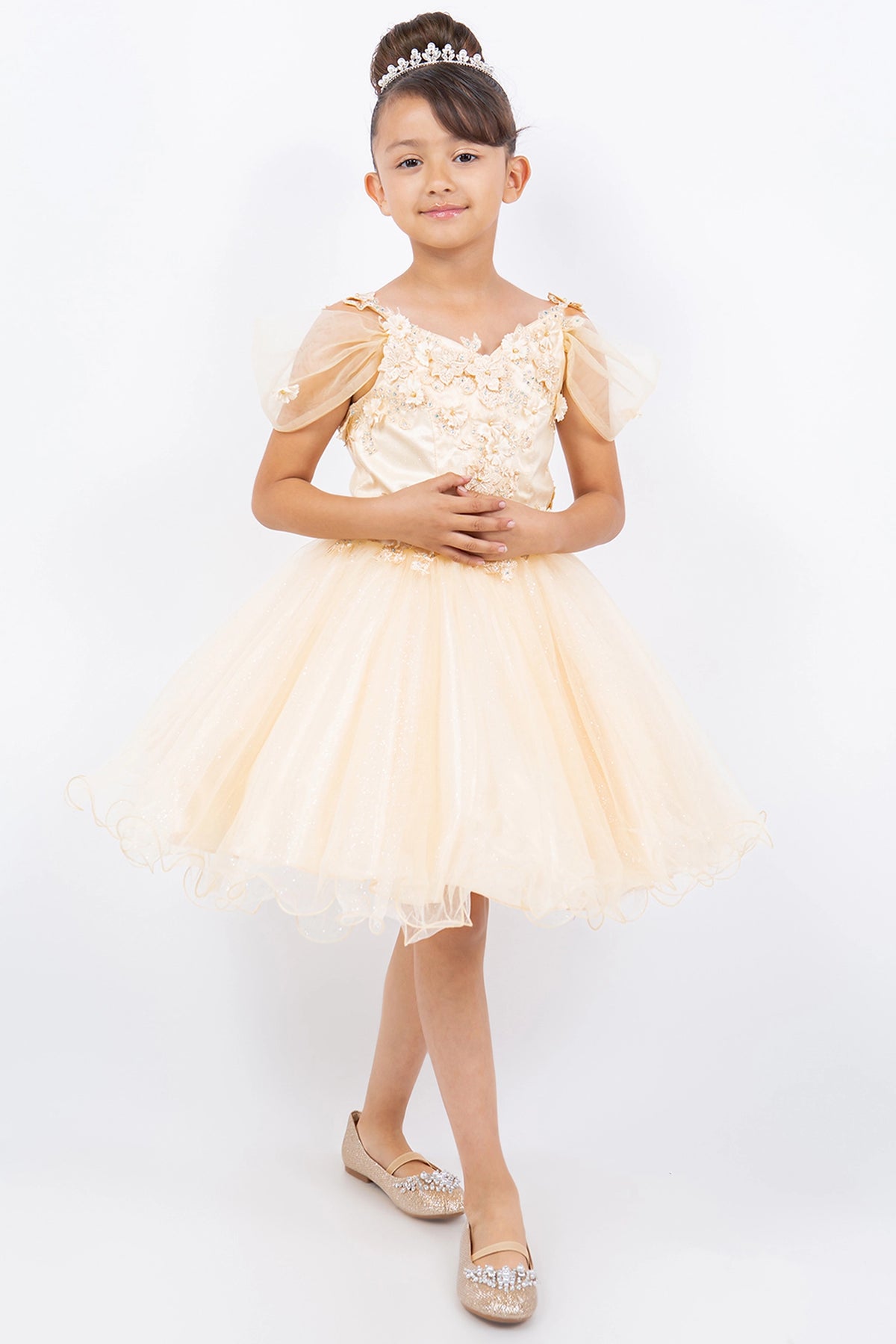 Showcasing with dimensional flowers at the shoulders, this Champagne kids party dress displays elegant detail.