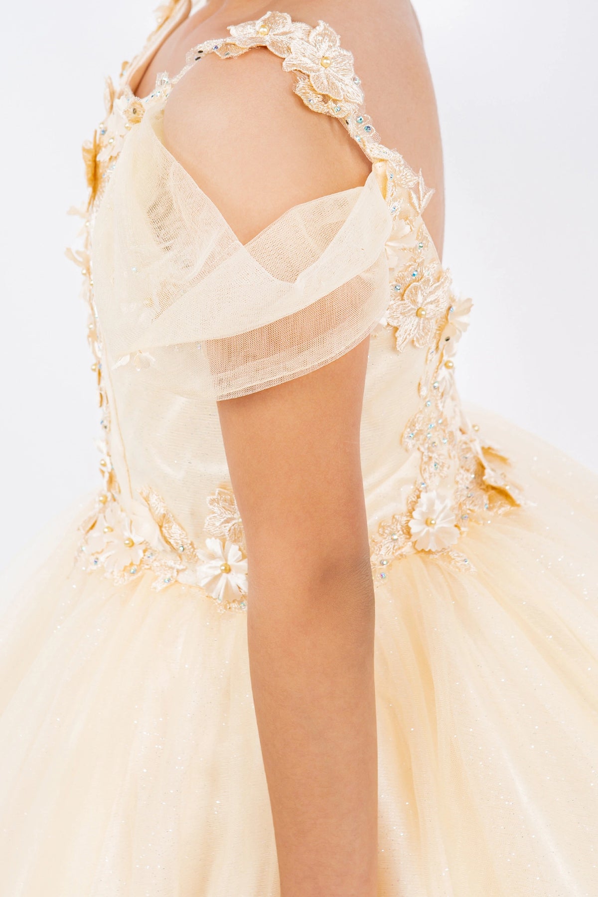 Featuring with dimensional flowers at the shoulders, this Champagne kids party dress displays elegant detail.