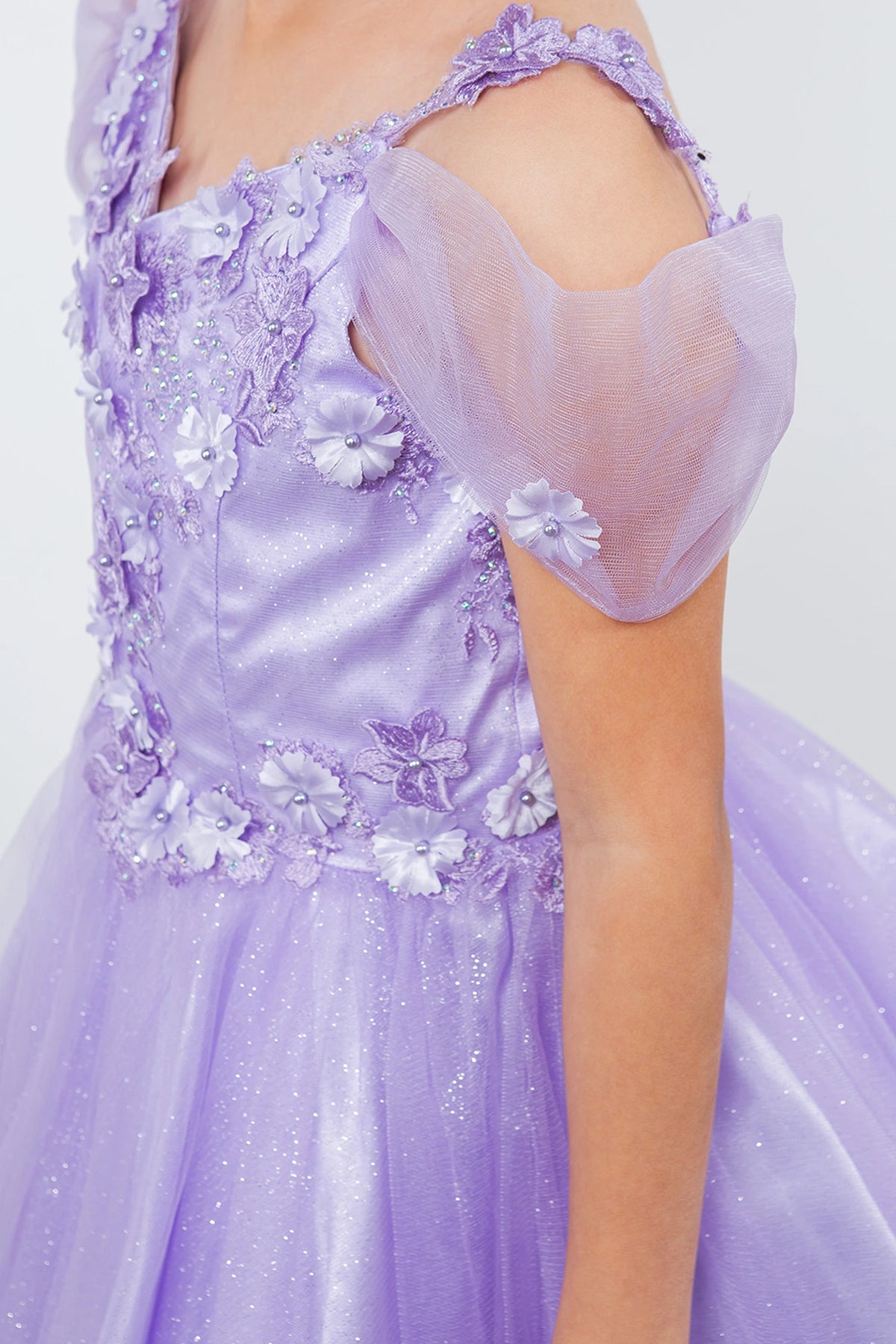 Designed details of dimensional flowers at the shoulders distinguish the Lavendar kids party dress.