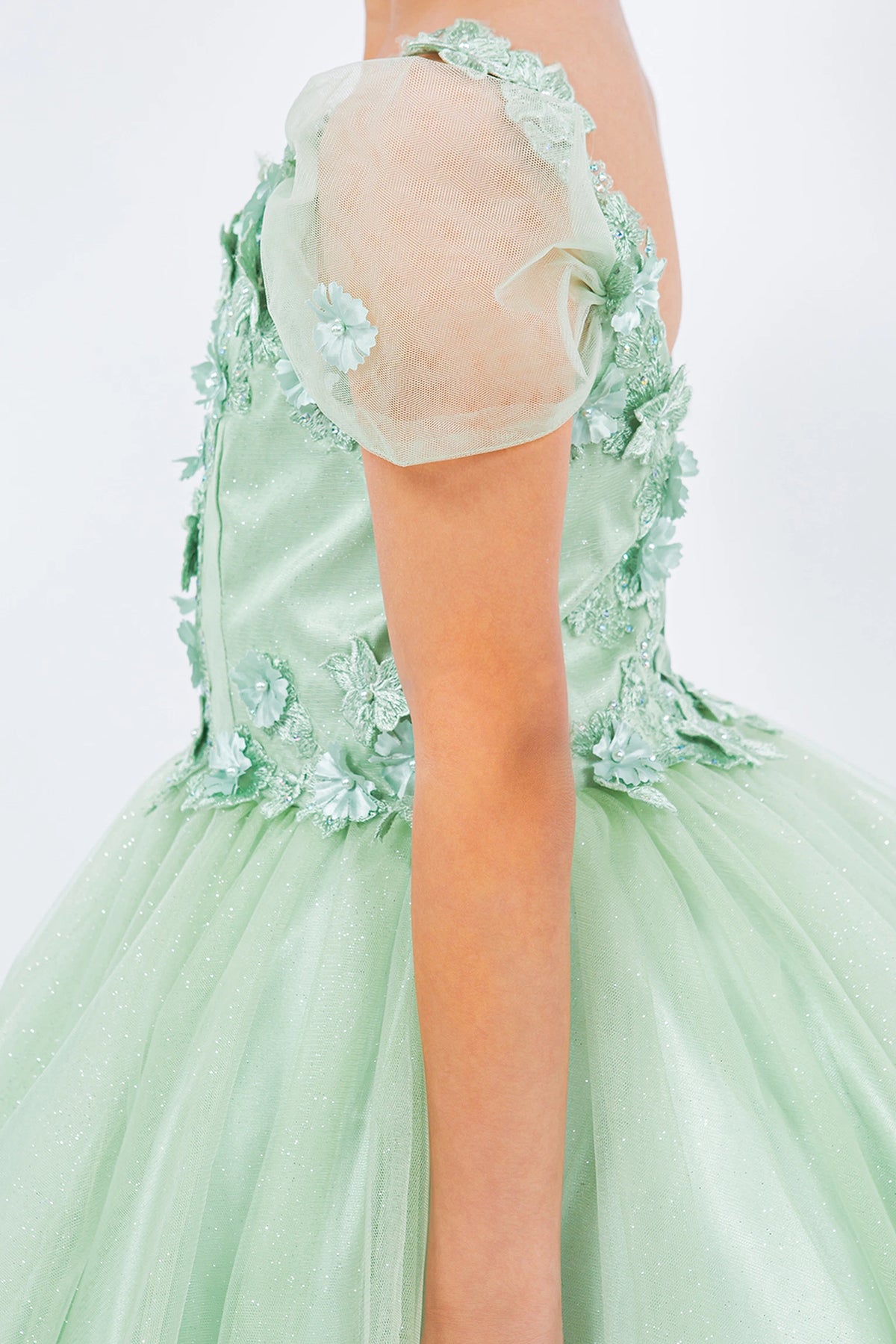 Featuring with dimensional flowers at the shoulders, this Sage kids party dress displays elegant detail.