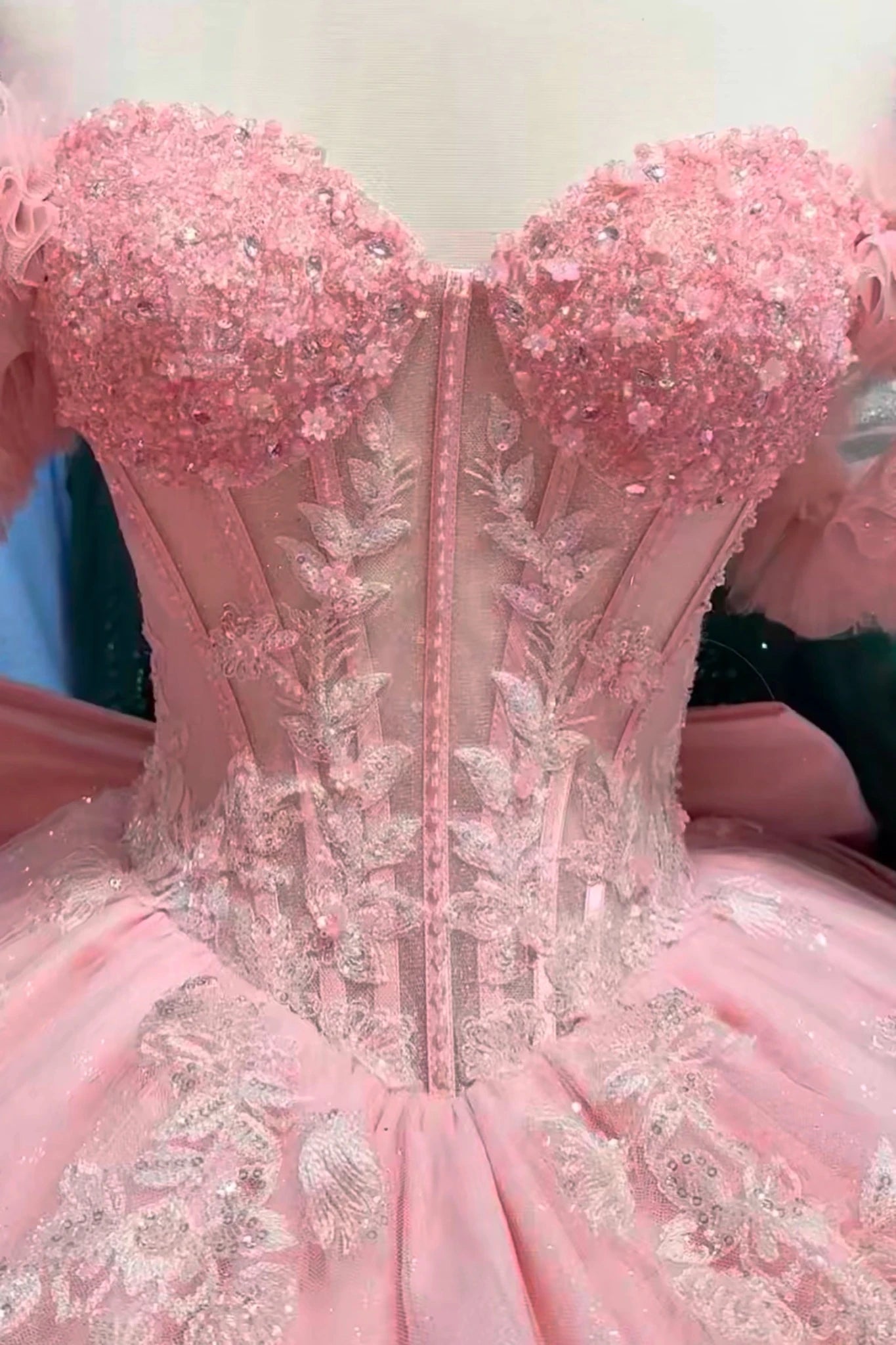 close-up the bust area of the blush quince dress showing intricate detailing and embellishments.