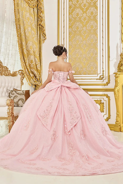 Woman back-facing in blush off-shoulder sweetheart quinceañera dress with lace-up corset bodice, embroidery, glitter tulle, and cascading full skirt