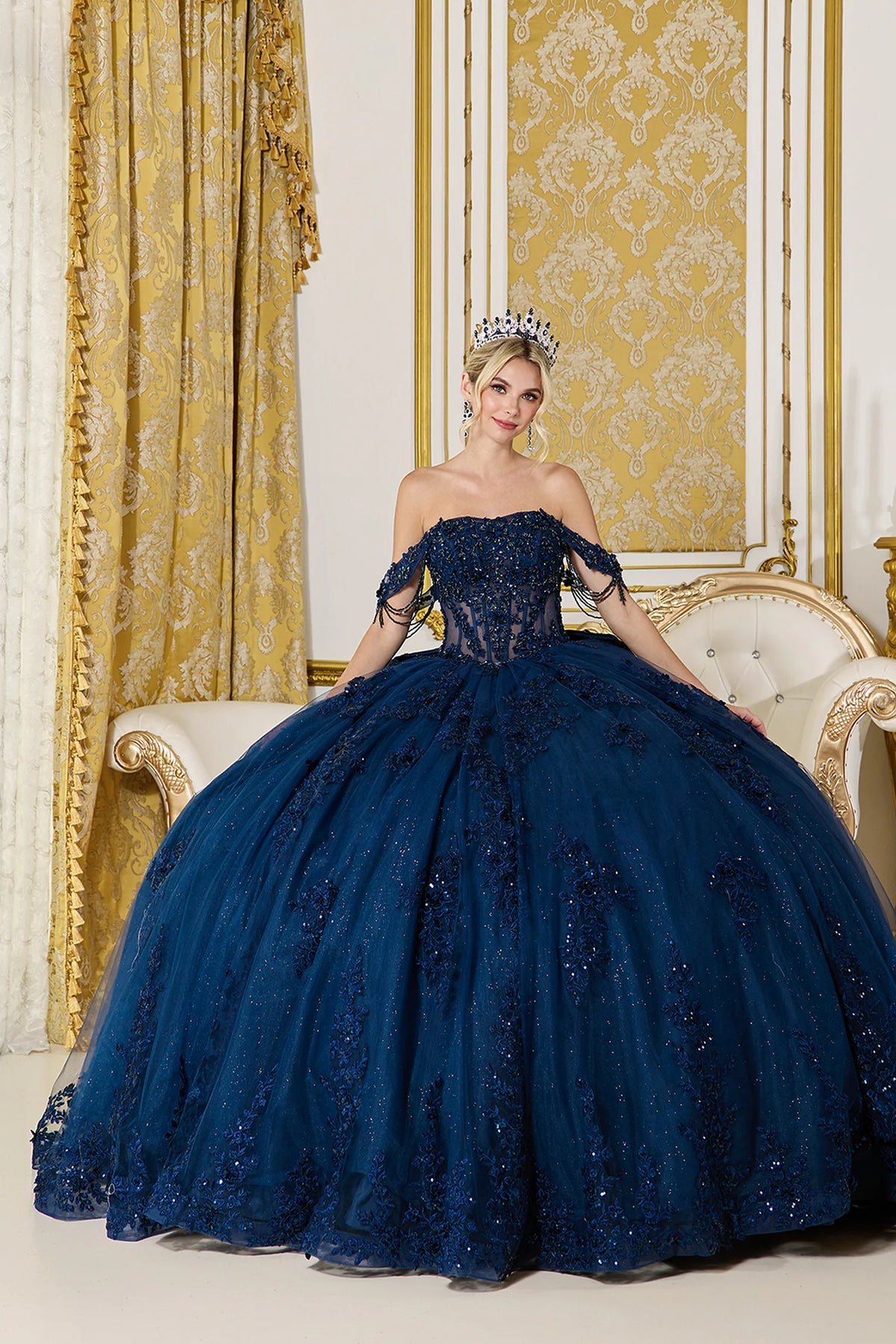 Showing dimensional appliqués and a full glitter tulle skirt, this Navy quinceañera ball gown is shown in full view.