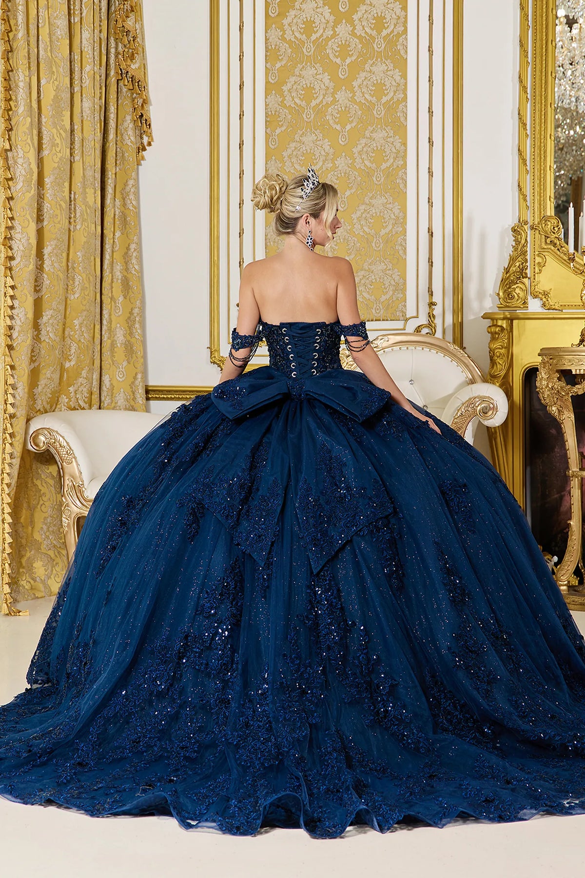 Revealing a lace-up back above its embellished train, this Navy quinceañera ball gown is shown from the back.