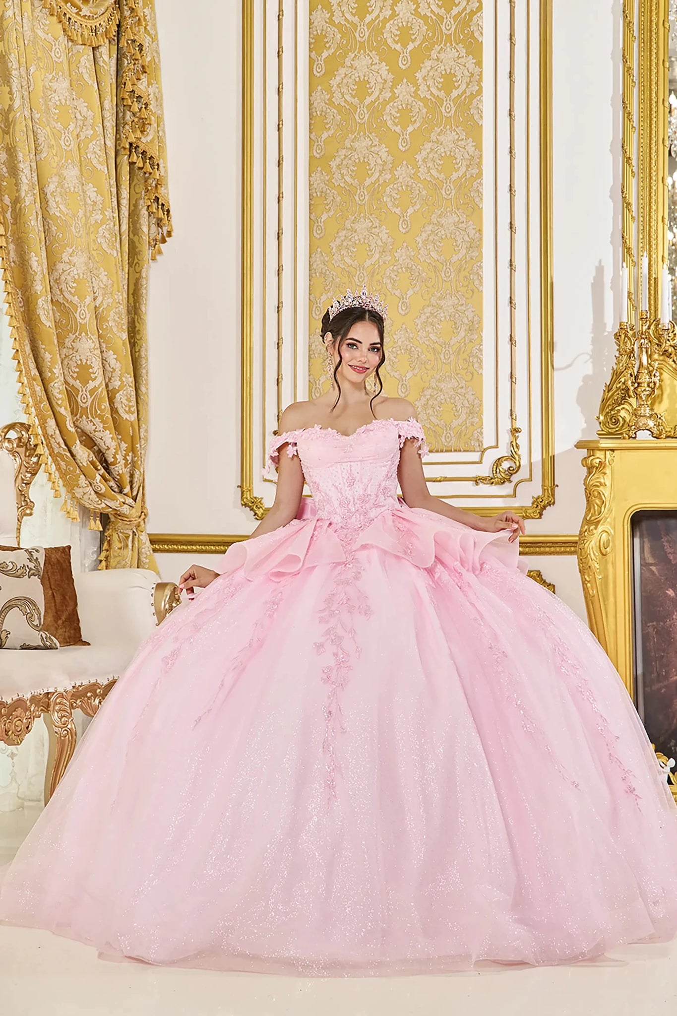 Woman in Pink off-shoulder quinceañera ball gown with floral corset and ruffle tulle skirt.