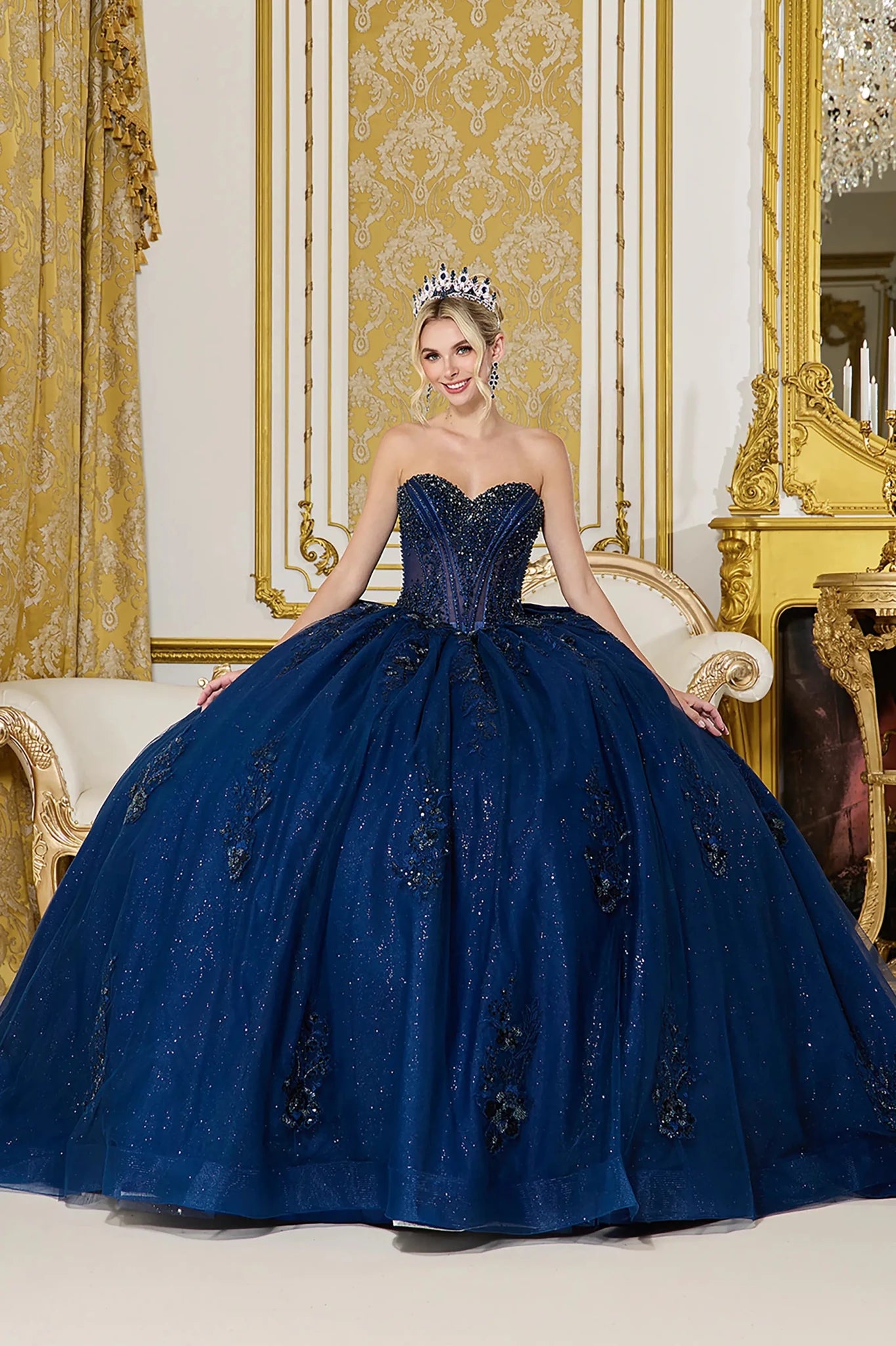 Woman in Navy strapless quinceañera ball gown with corset bodice and full glitter tulle skirt.