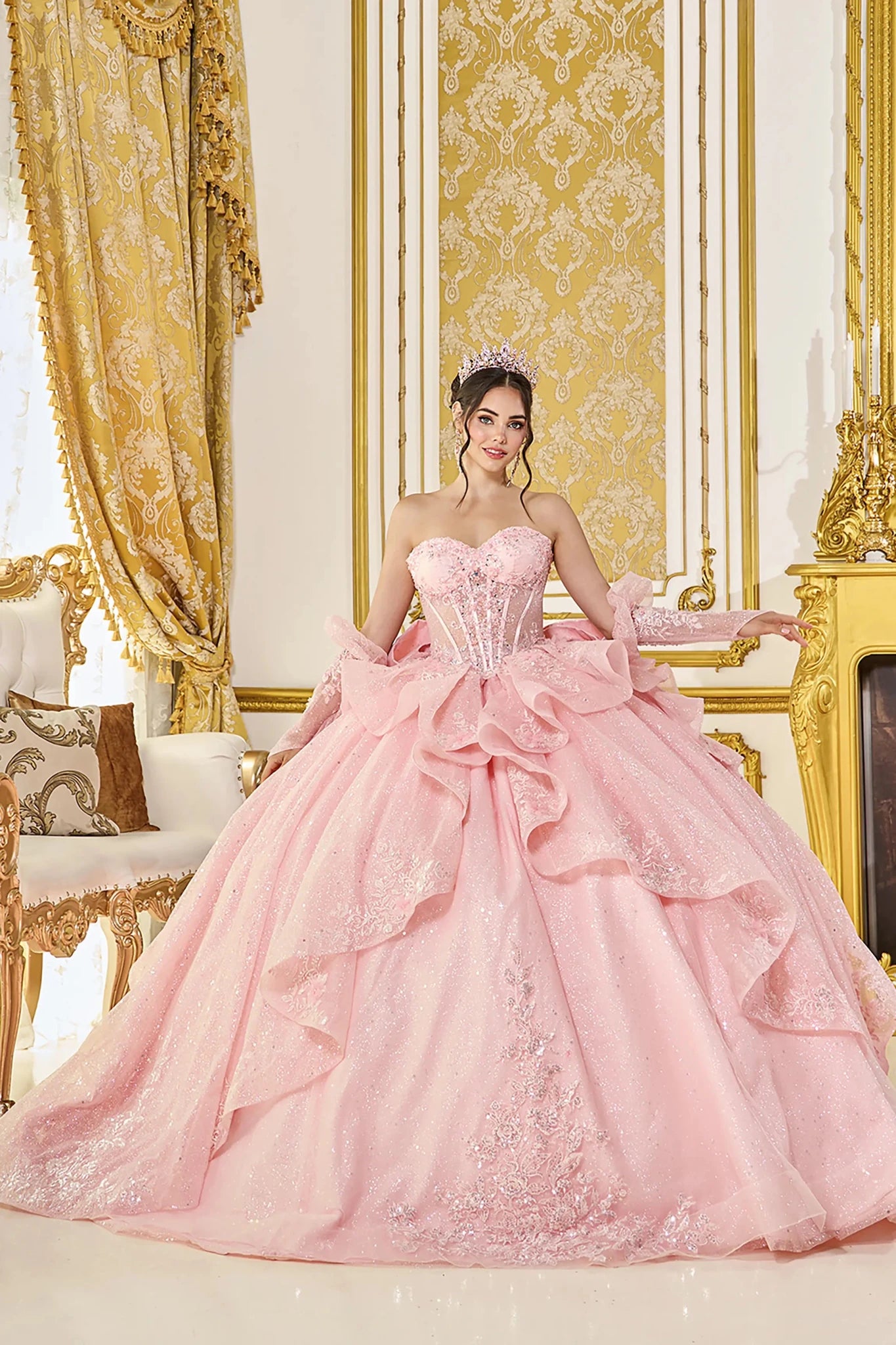 Woman in Blush strapless quinceañera ball gown with corset bodice and detachable sleeves.