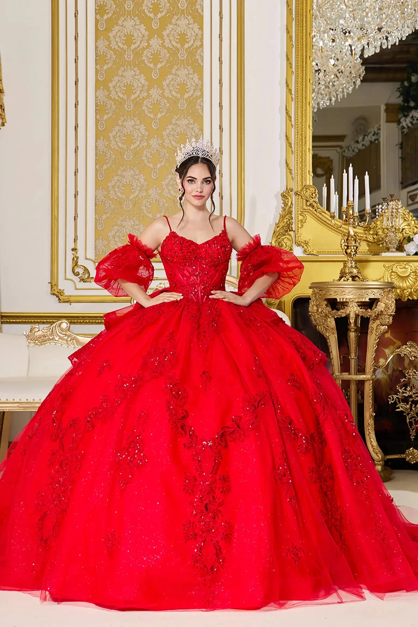 Woman standing front-facing in elegant red ball gown with detachable puff sleeves, beaded bodice, and voluminous layered tulle skirt