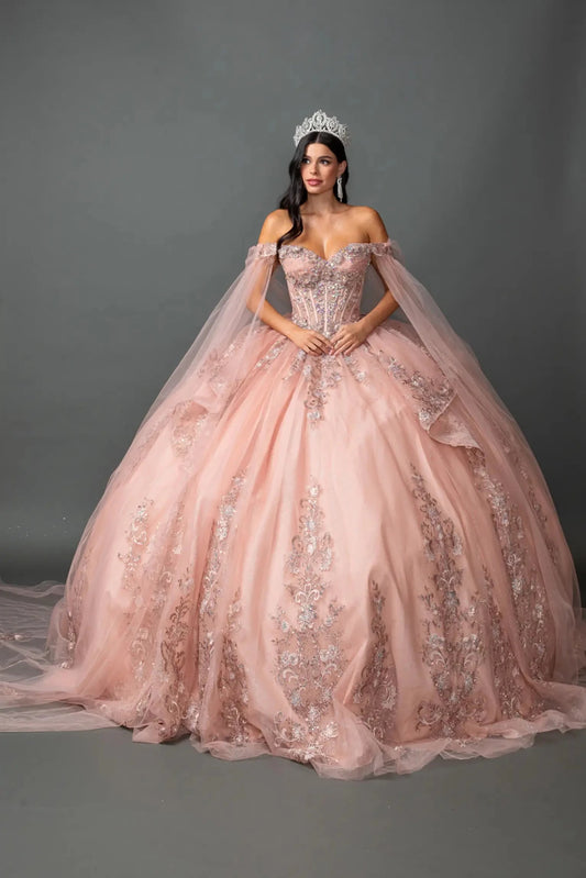 Woman standing front-facing in elegant rose gold ball gown with floral appliqué bodice, glitter tulle skirt, and voluminous layered silhouette