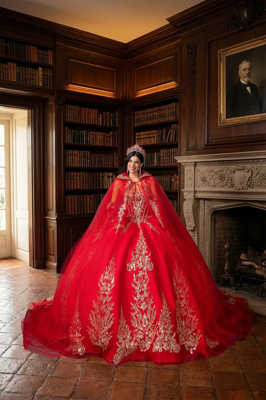 Woman wearing red off-shoulder ball gown quinceañera dress with embroidered corset bodice, ornate appliqué, detachable hooded cape, and full tulle skirt