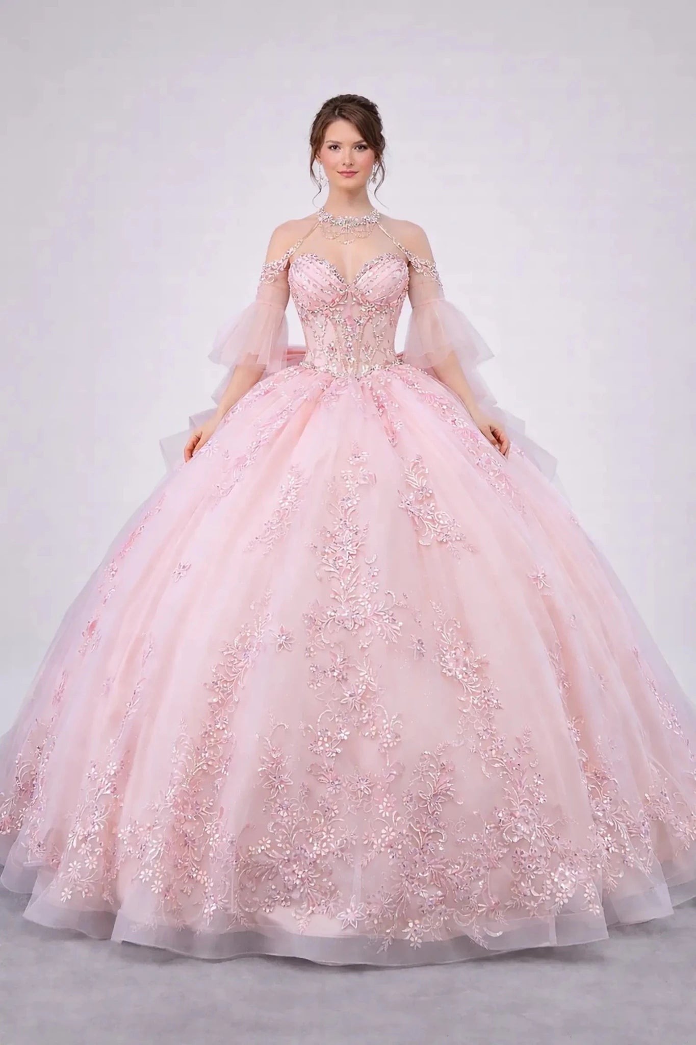 Woman standing front-facing in elegant blush ball gown with embellished corset bodice and voluminous full tulle skirt

