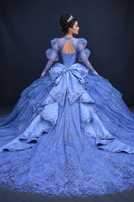 Back view of a woman wearing dusty blue quinceañera, detachable cape, lace-up corset, ruffle skirt, puff sleeves