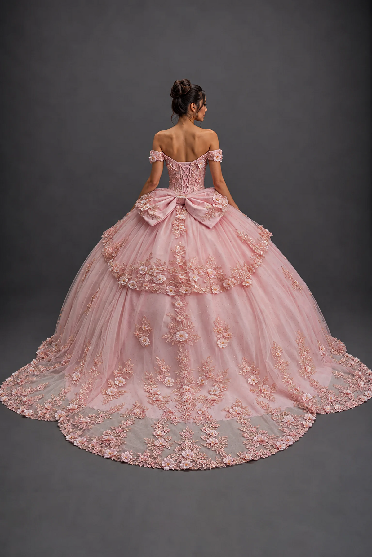 Back view of blush quinceañera dress with lace-up corset, bow, 3D florals and train