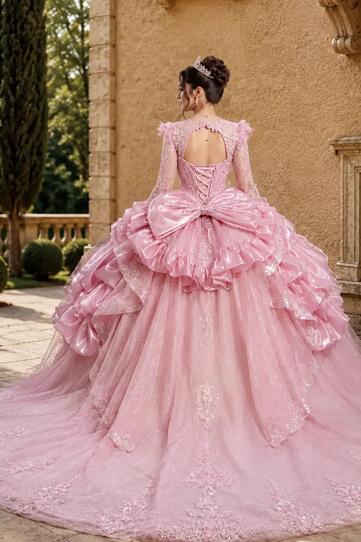 blush quinceanera ball gown with lace-up corset back, tiered overskirt, glitter tulle layers, statement bow and chapel-length train