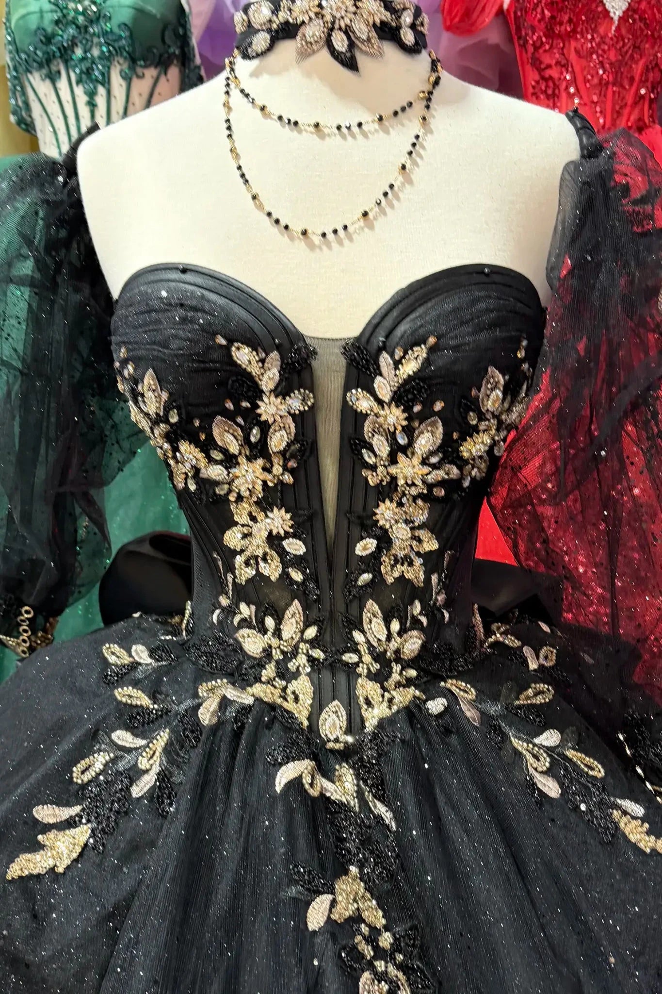 top of the black quincenera dress with gold big rhinestones and necklace