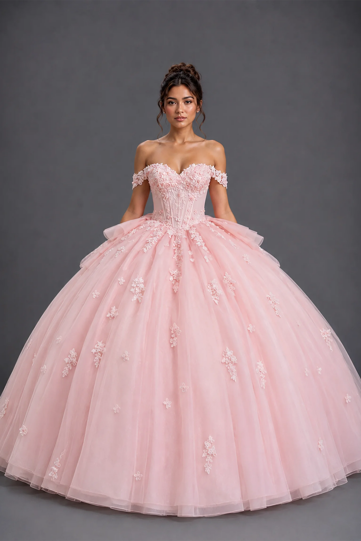 Front view of blush quinceañera dress with floral appliqué bodice and full tulle ball gown skirt