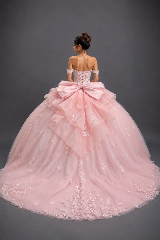 Back view of blush quinceañera dress with lace-up corset, bow and floral tulle train