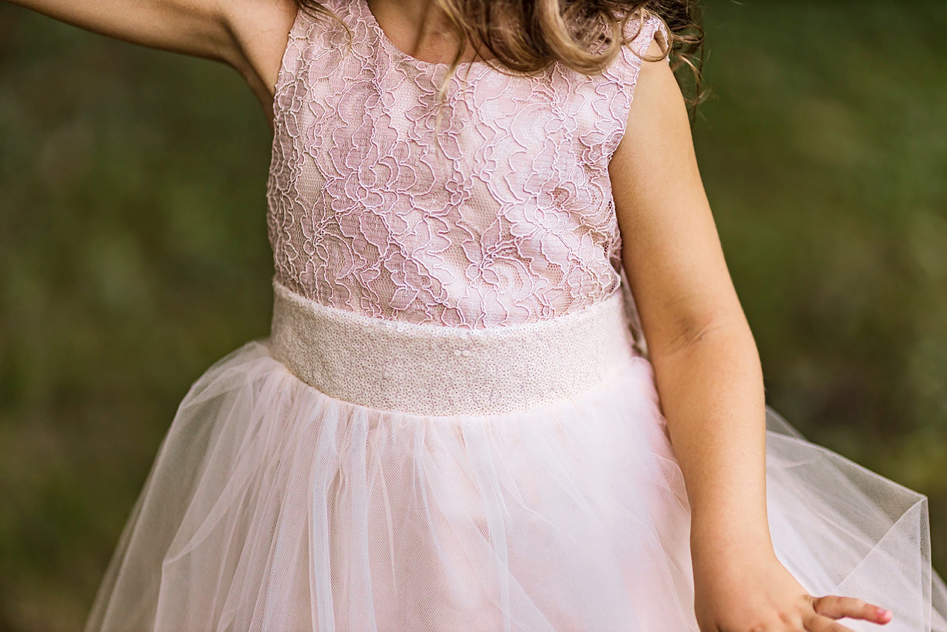Sleeveless lace tulle flower girl dress with deep V-back design, sequin detailing, and layered tulle skirt.