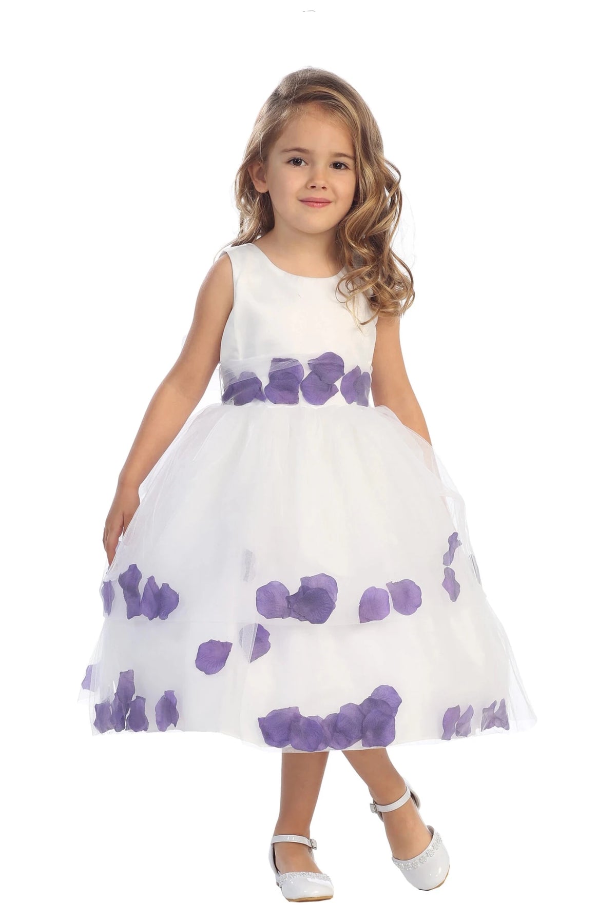 Purple petals sit inside the white flower girl dress's tulle hem.