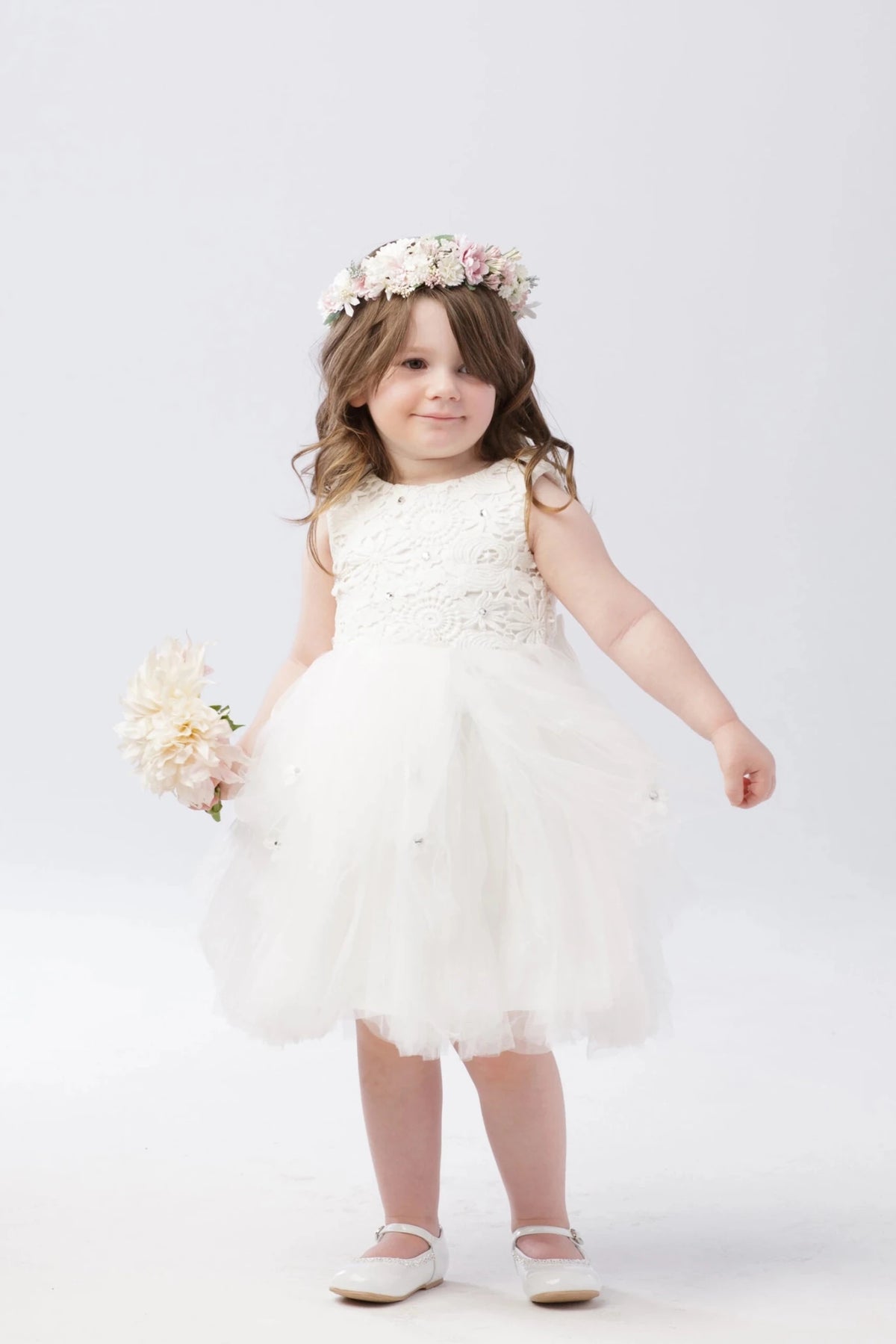 Soft ruffled tulle skirt shown on the off-white flower girl dress.