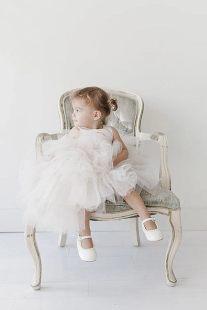 Seen from the front, this Ivory kids pageant dress displays a satin bodice and layered high-low tulle.
