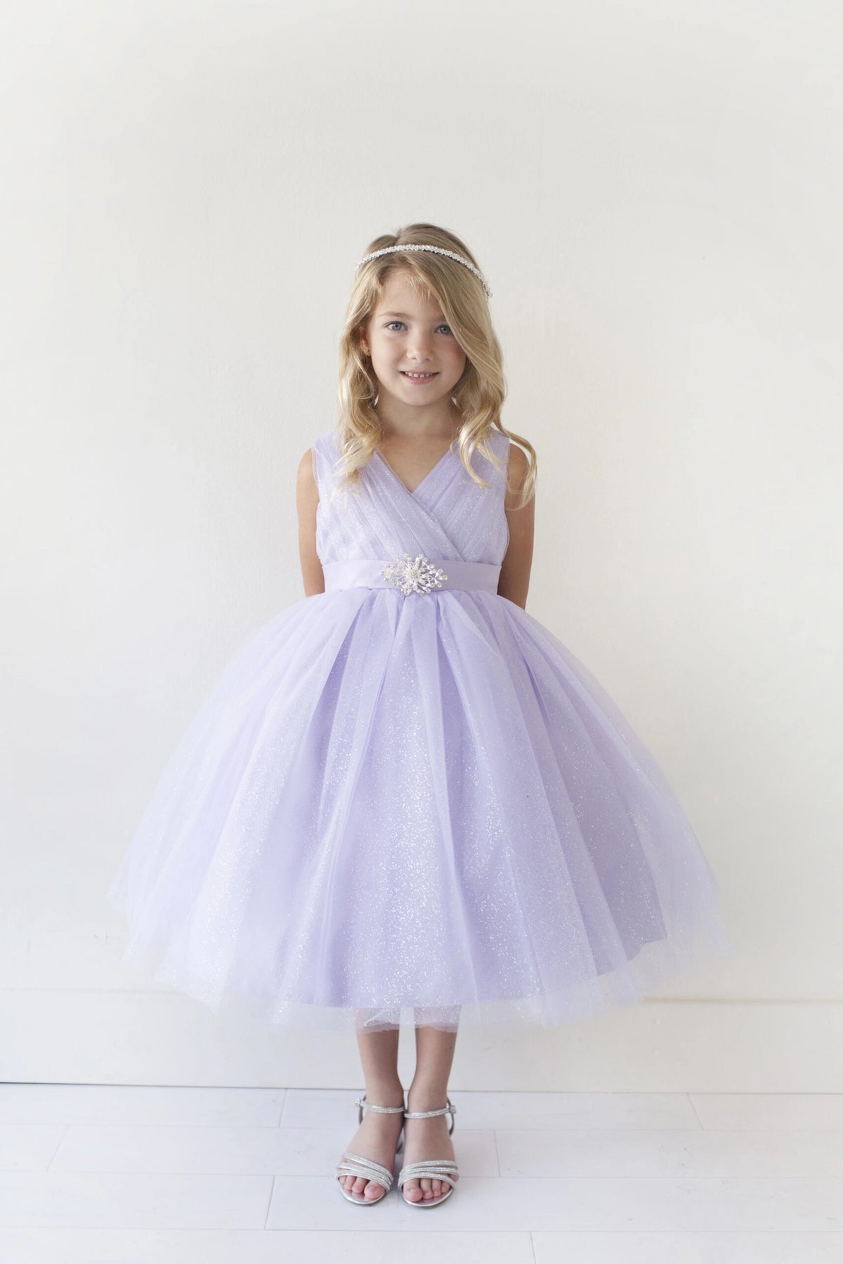 Lilac kids pageant dress featuring a ruched V-neckline and rhinestone brooch.