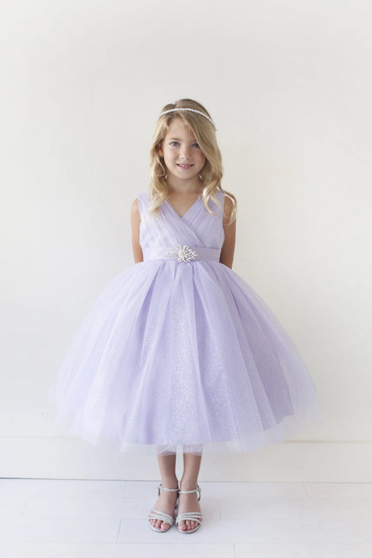 Lilac kids pageant dress featuring a ruched V-neckline and rhinestone brooch.