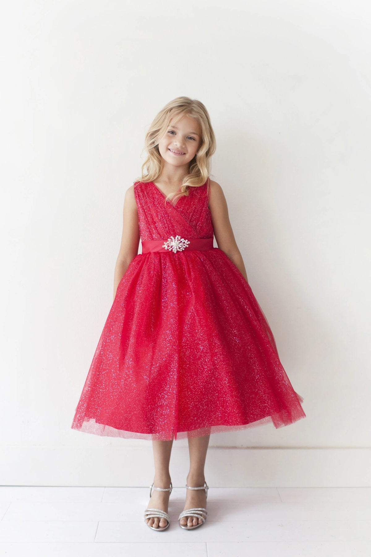 Red kids pageant dress featuring a ruched V-neckline and rhinestone brooch.