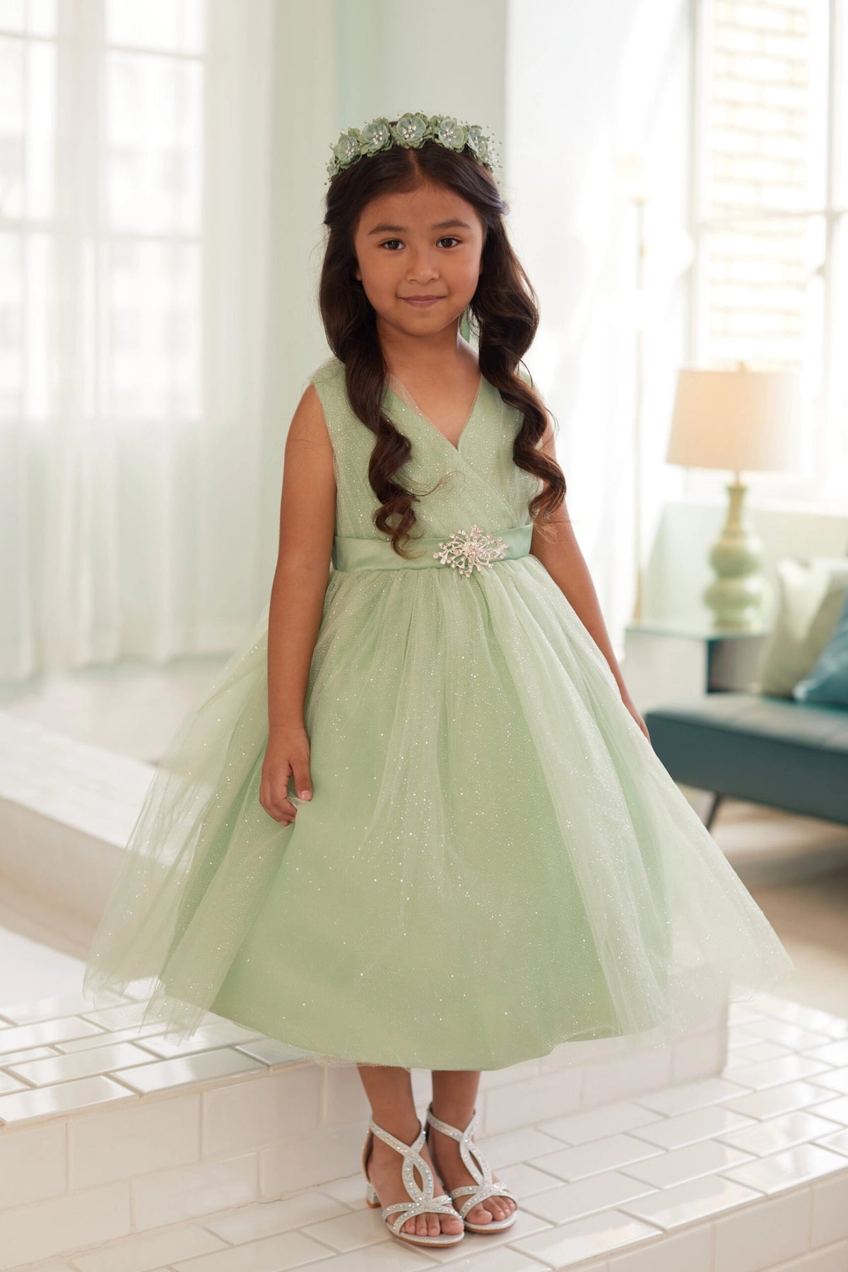 The Sage kids pageant dress has a ruched V-neckline and rhinestone brooch.