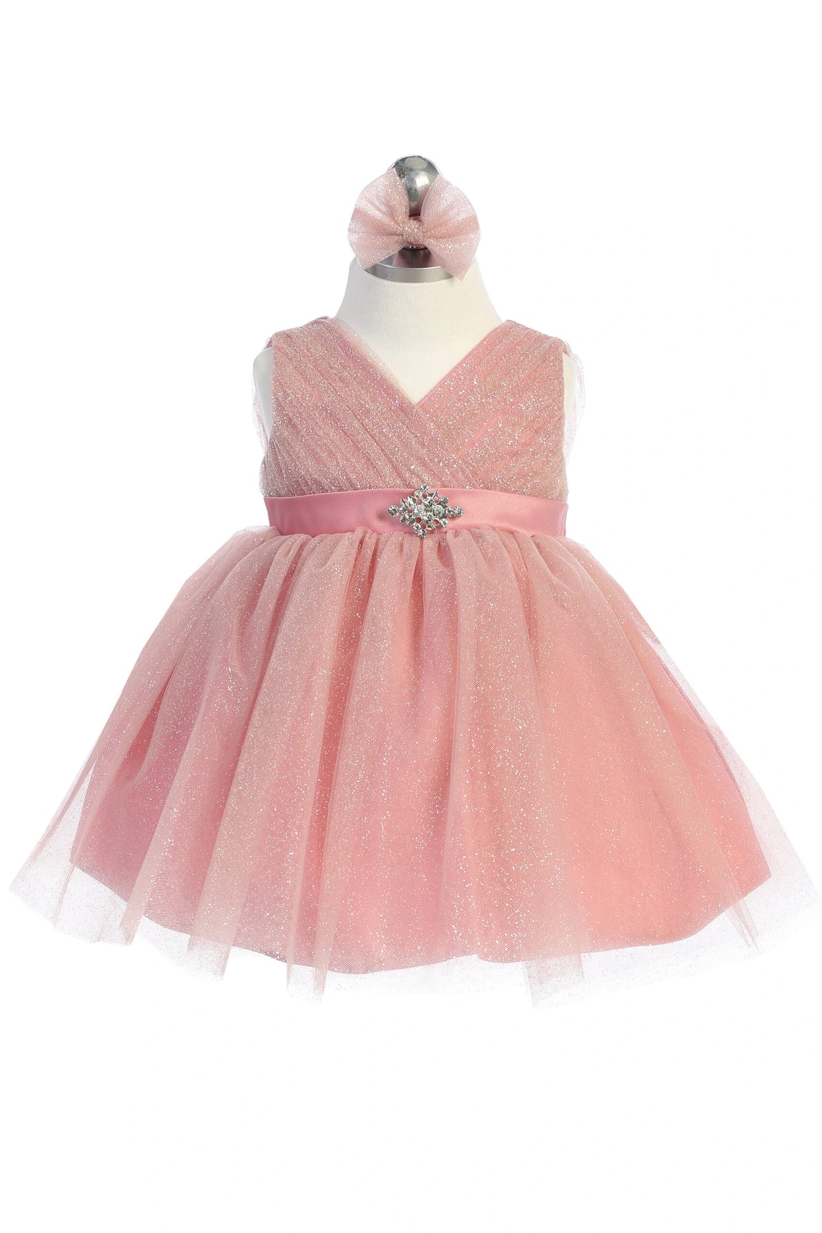 Blush kids pageant dress featuring a ruched V-neckline and rhinestone brooch.