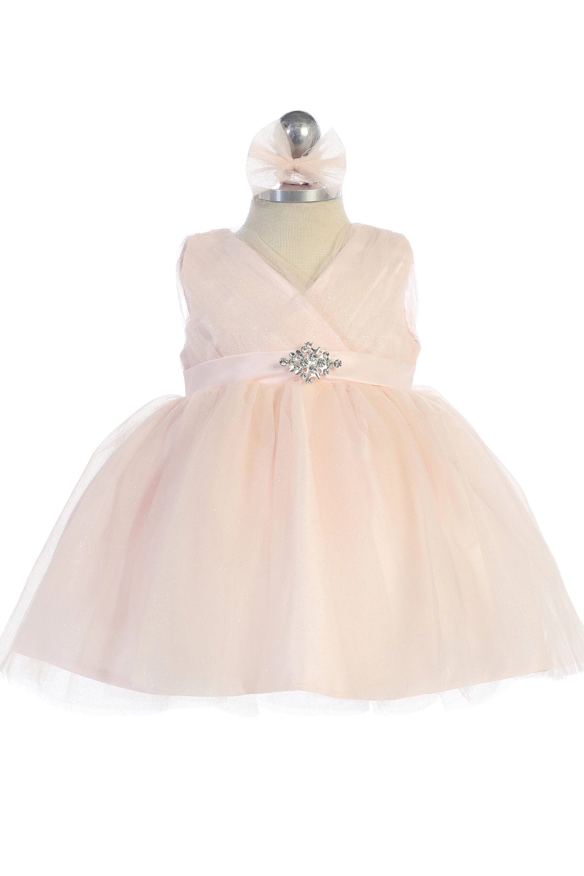 The Blush kids pageant dress has a ruched V-neckline and rhinestone brooch.