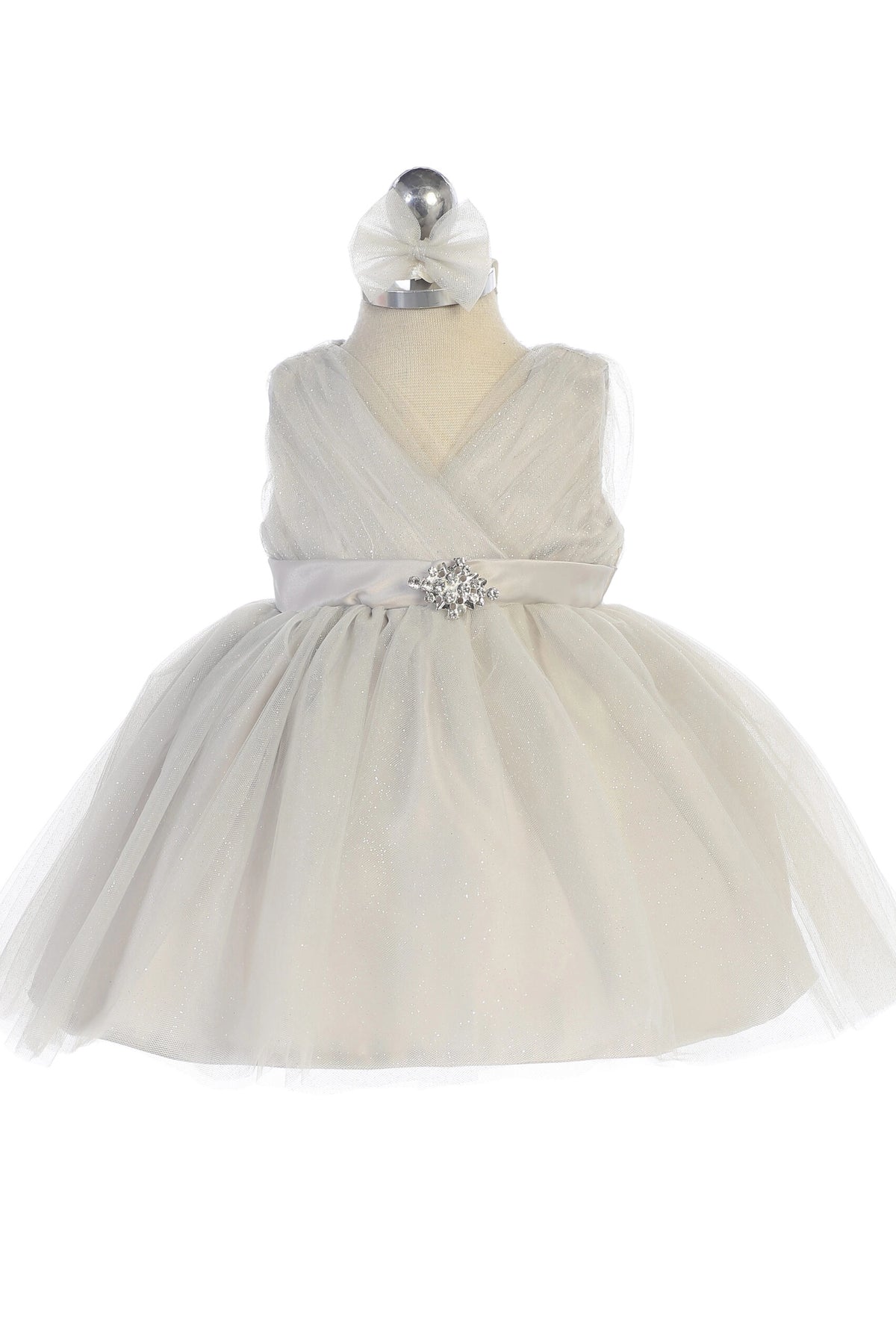 Silver kids pageant dress featuring a ruched V-neckline and rhinestone brooch.