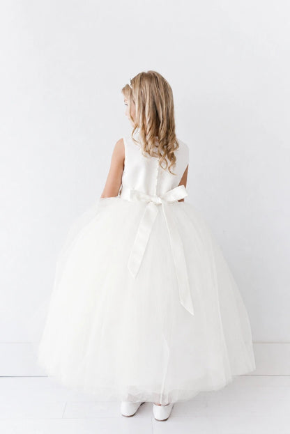 Shown here, an off-white flower girl dress with a satin back bow.