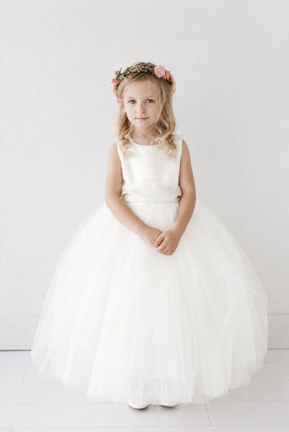 Featuring a gathered tulle skirt, an off-white flower girl dress.