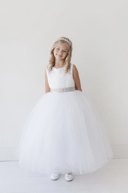 This white flower girl dress displays a beaded waist band.