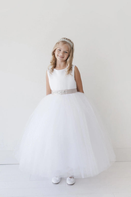 This white flower girl dress displays a beaded waist band.