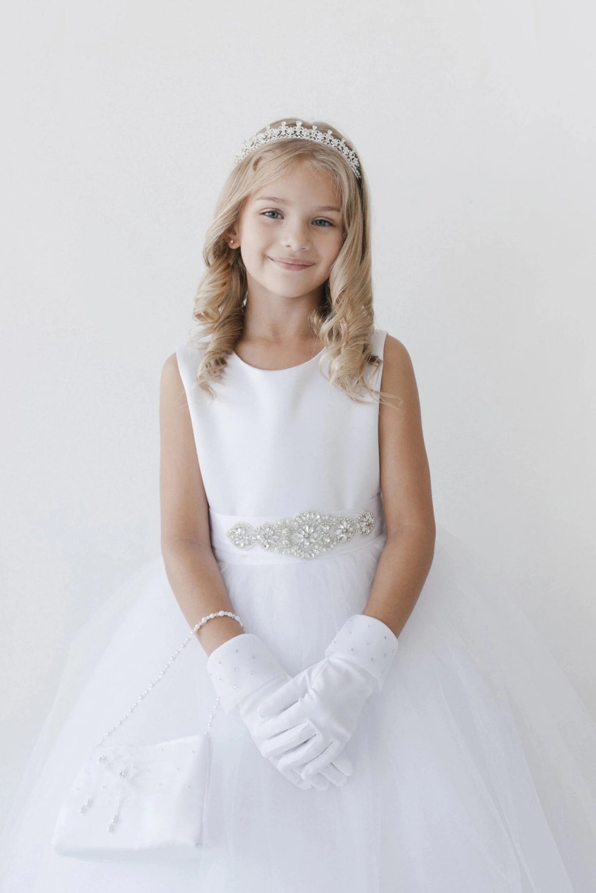 With a sparkling waist ornament, a white flower girl dress.
