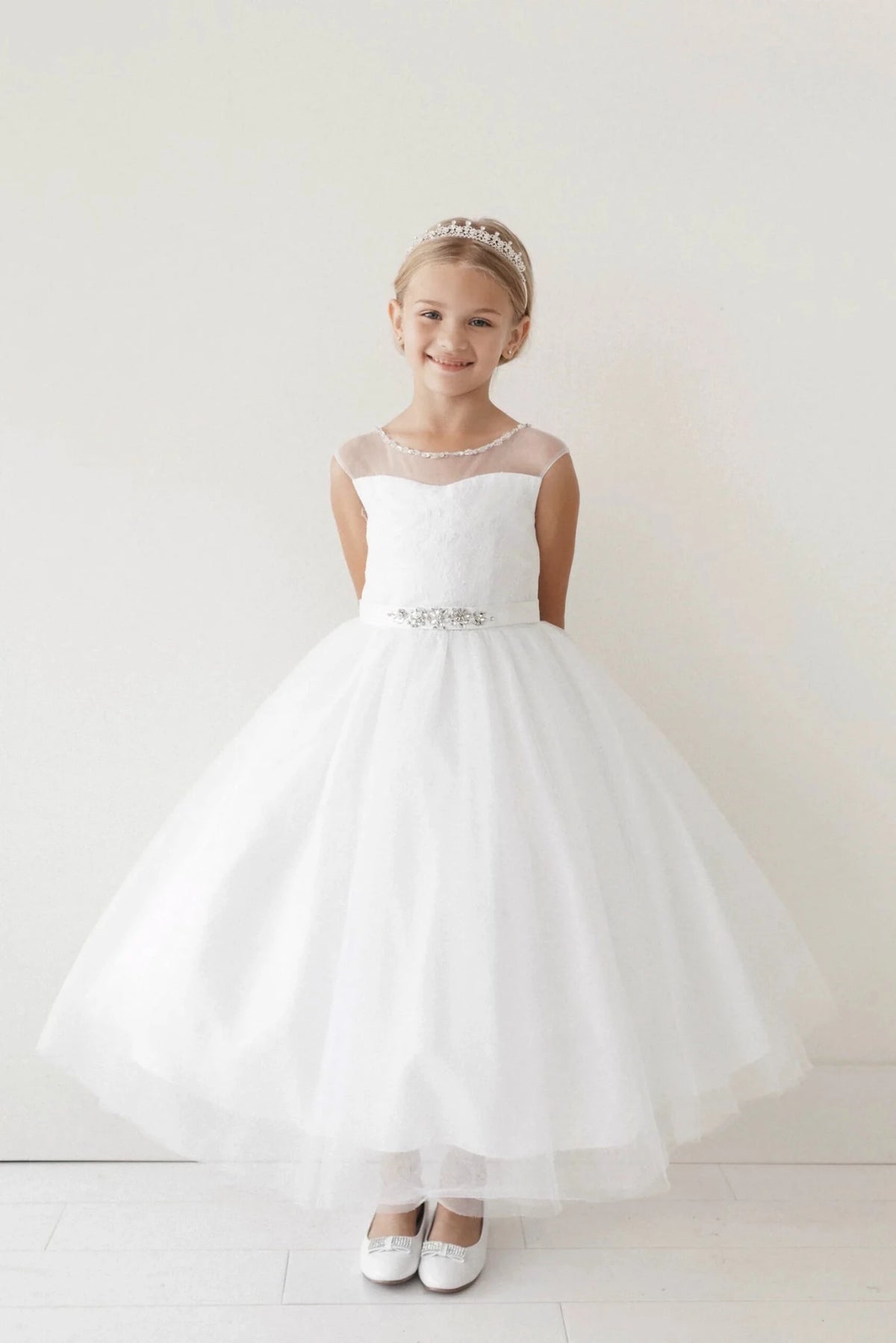 Airy tulle gives this off-white flower girl dress a wide skirt.