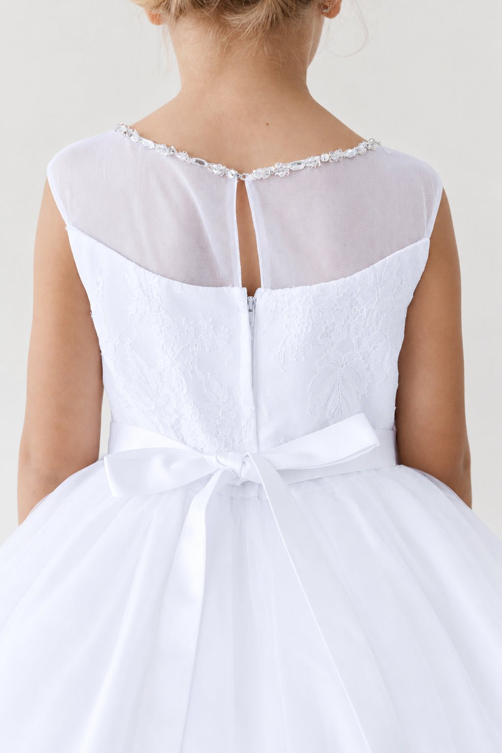 Back mesh meets a small keyhole on this white flower girl dress.
